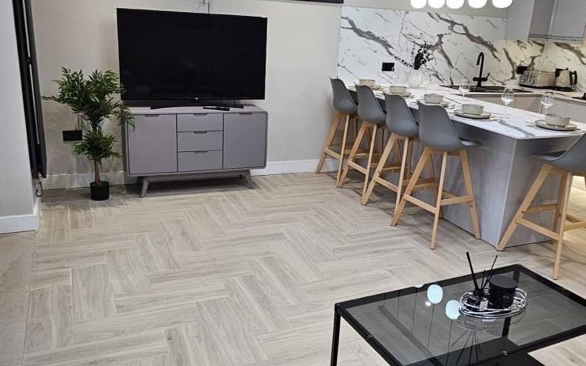 Open-plan kitchen and dining space with a marble breakfast bar and herringbone floors &mdash; The Zoo House, a Gales-managed home near Chester Zoo